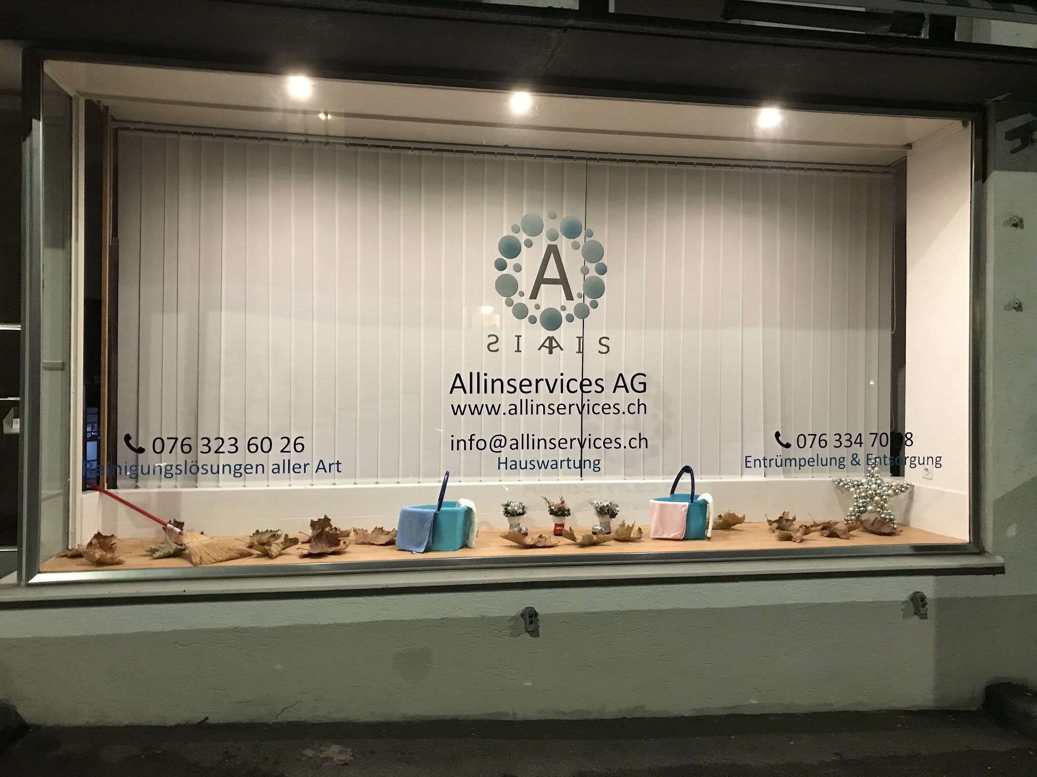 Schaufenster der Allinservices AG an der Altstetterstrasse mit Logo und Telefonnummern