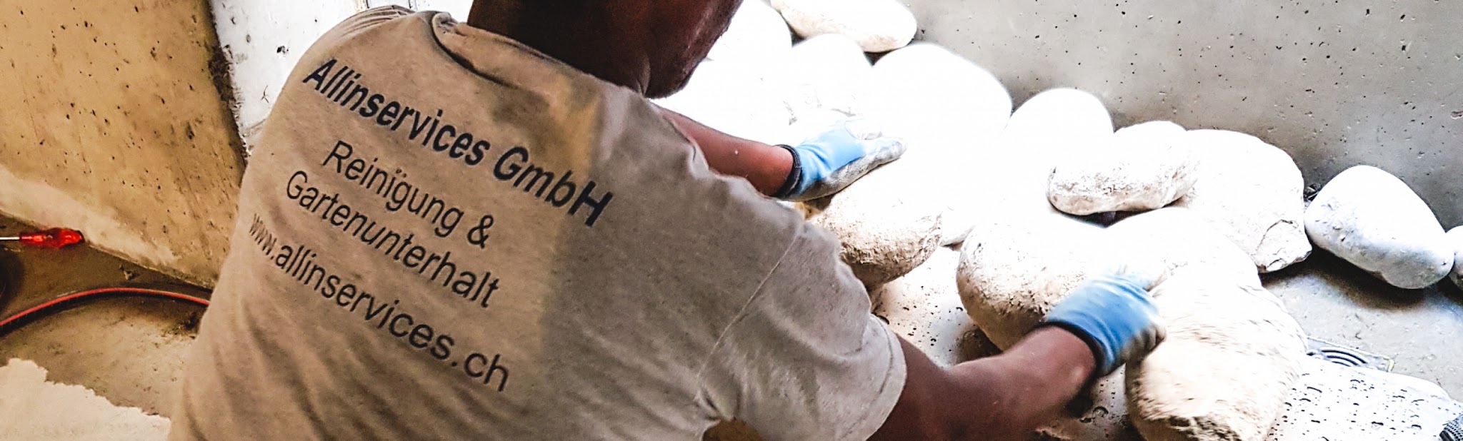 Mitarbeiter mit Handschuhen bei Steinen und Kies